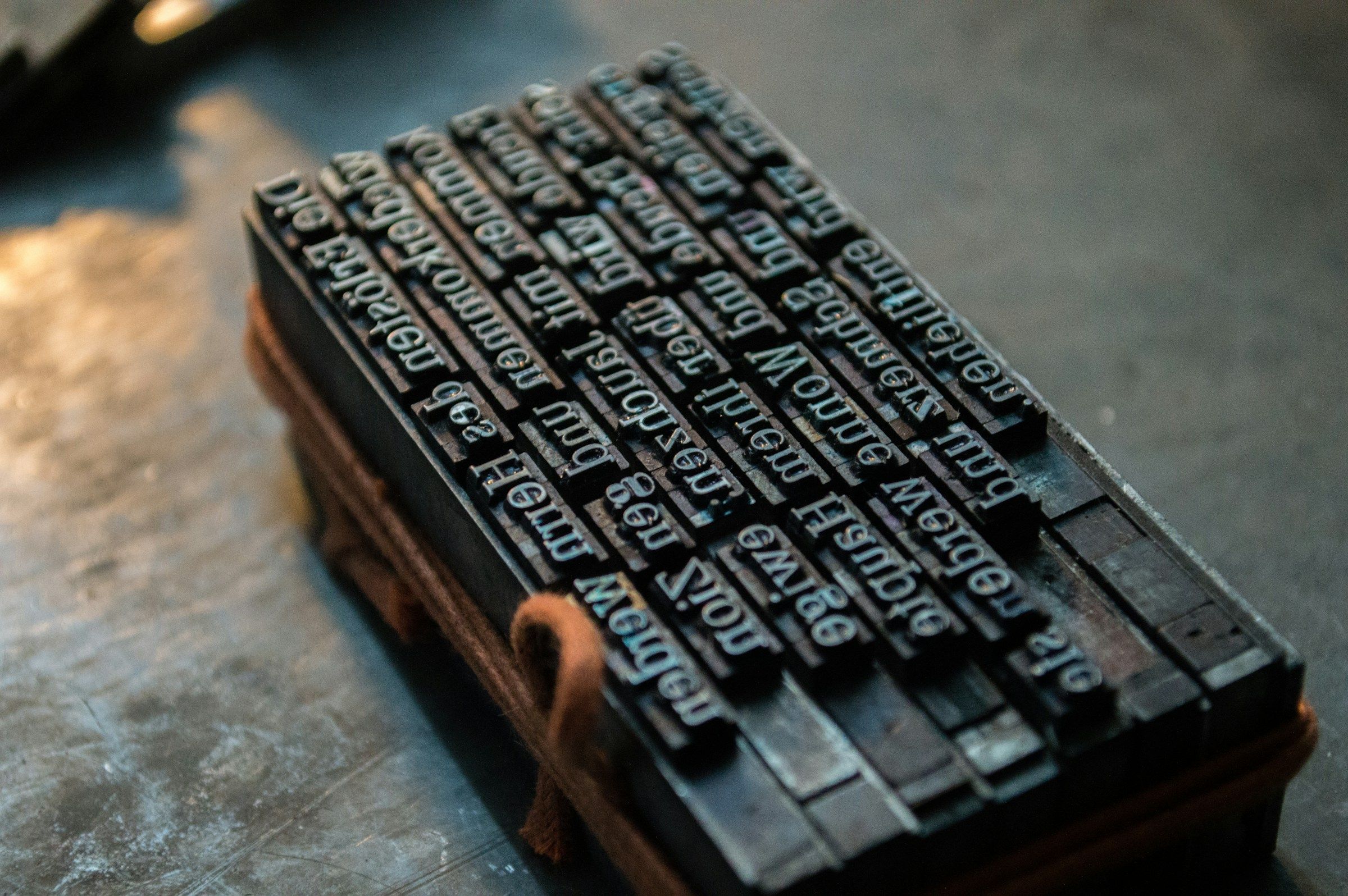 Des caractères d'imprimerie en plomb serrés dans un châssis de bois, les lettres en relief et inversées